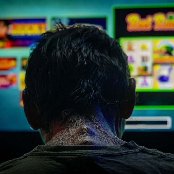 A man spends the three dollars in his pocket playing a bar slot machine in downstate Golconda on June 4, and then leaves. (Credit: Julia Rendleman for Capitol News Illinois)